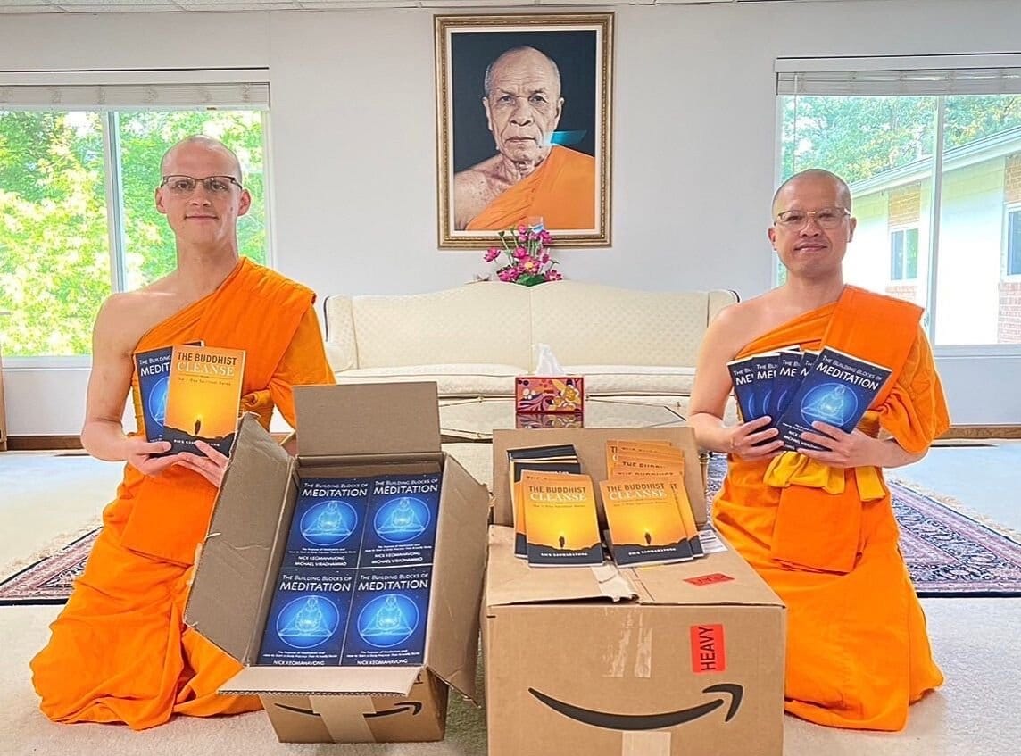 Two monks unpacking boxes of new books beneath a portrait of their teacher.