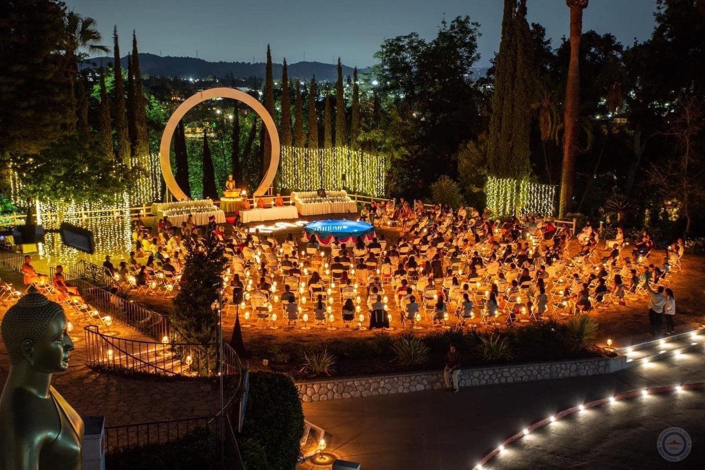 Rows of people meditating by candlelight