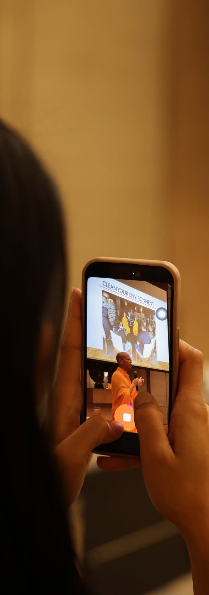A visitor filming a candlelit ceremony on their phone.